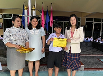 Giving a certificate with volunteer
students for the merit-making project,
giving alms to monks